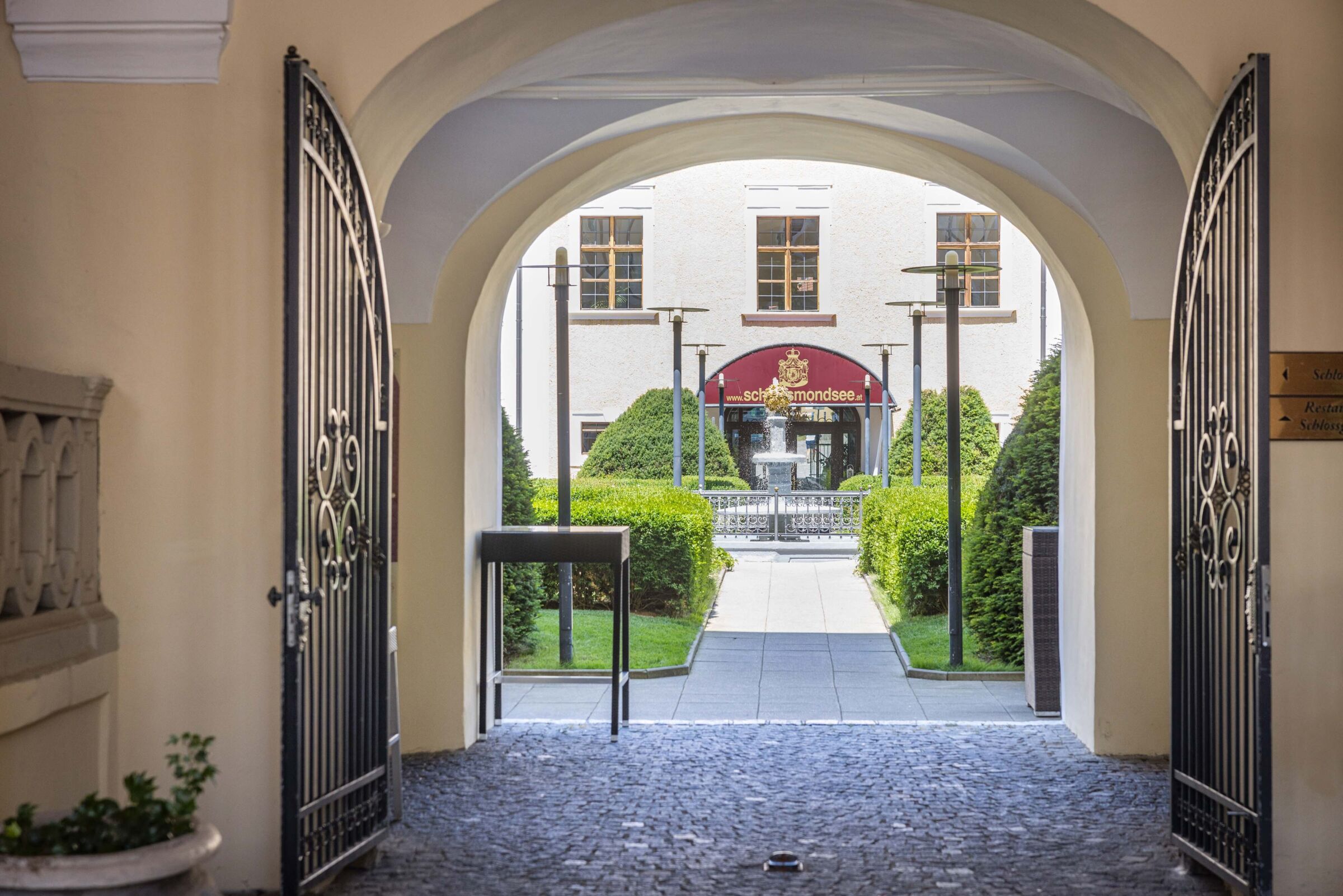 Eingang des Schlosses Mondsee mit historischer Fassade und offener Toranlage