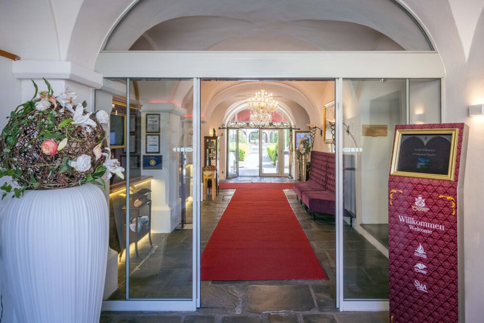 Einladender Eingangsbereich des Schlosshotels Mondsee mit historischem Portal