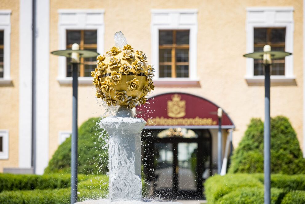 Schlossbrunnen mit elegantem Design im Schlossgarten von Schloss Mondsee – ein historisches Highlight im Grünen