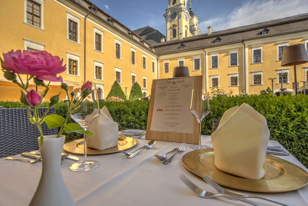 Ein gedeckter Tisch im Restaurant Culinaro am Mondsee - mit Blumen und einer Speisekarte für die Gäste