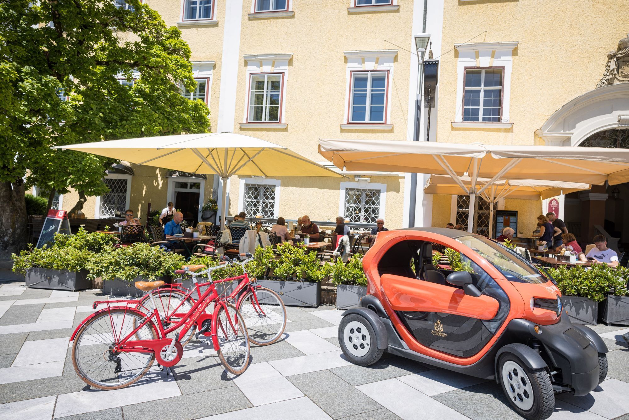 Leihfahrrad und E-Twizy vor dem Schlosshotel Mondsee – nachhaltige Mobilitätsangebote für entspannte Ausflüge rund um den Mondsee