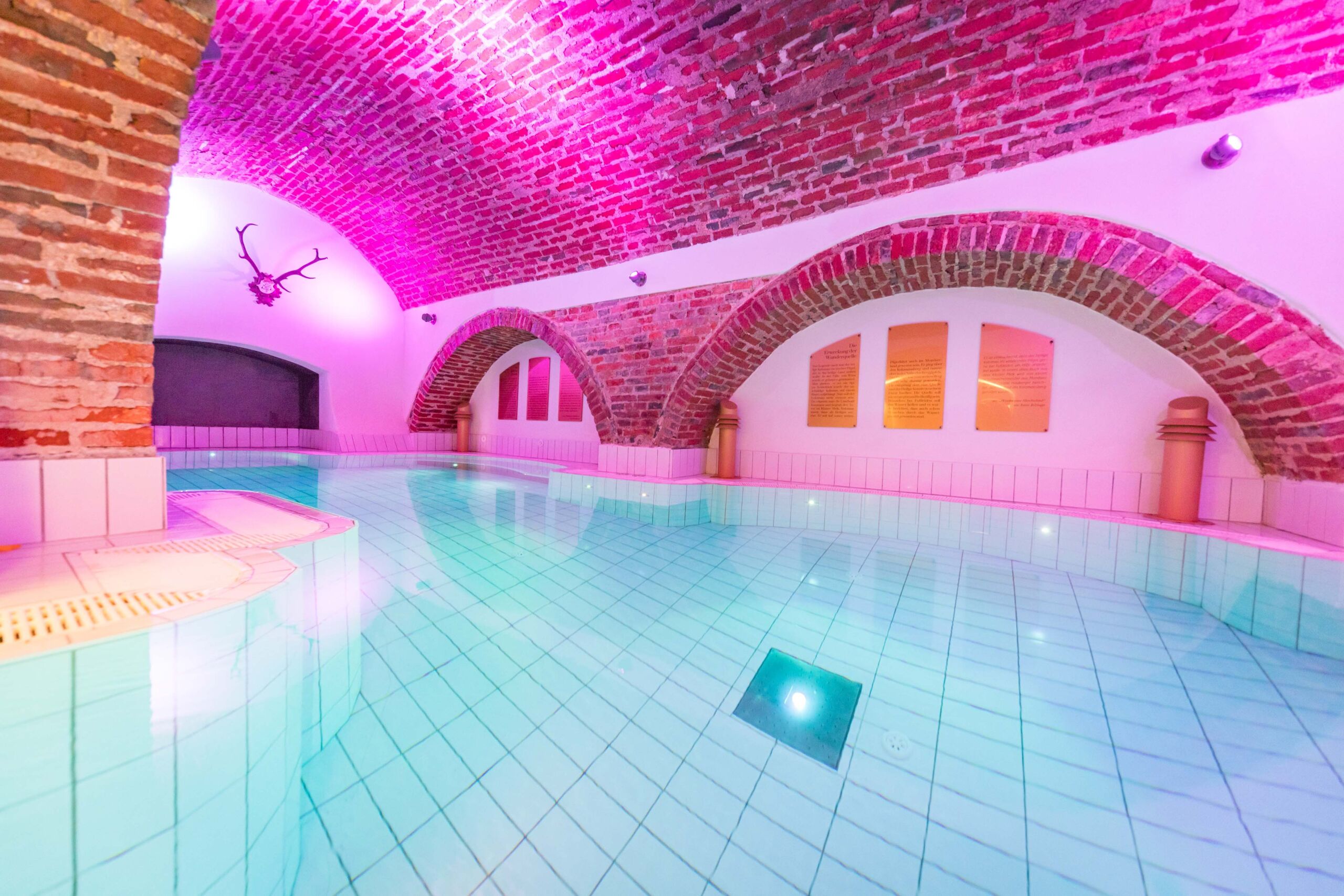 Historisches Gewölbebad mit entspannendem Wasserbereich, stimmungsvoller Beleuchtung und Wellness-Atmosphäre im Monasterium Spa des Schlosshotels Mondsee