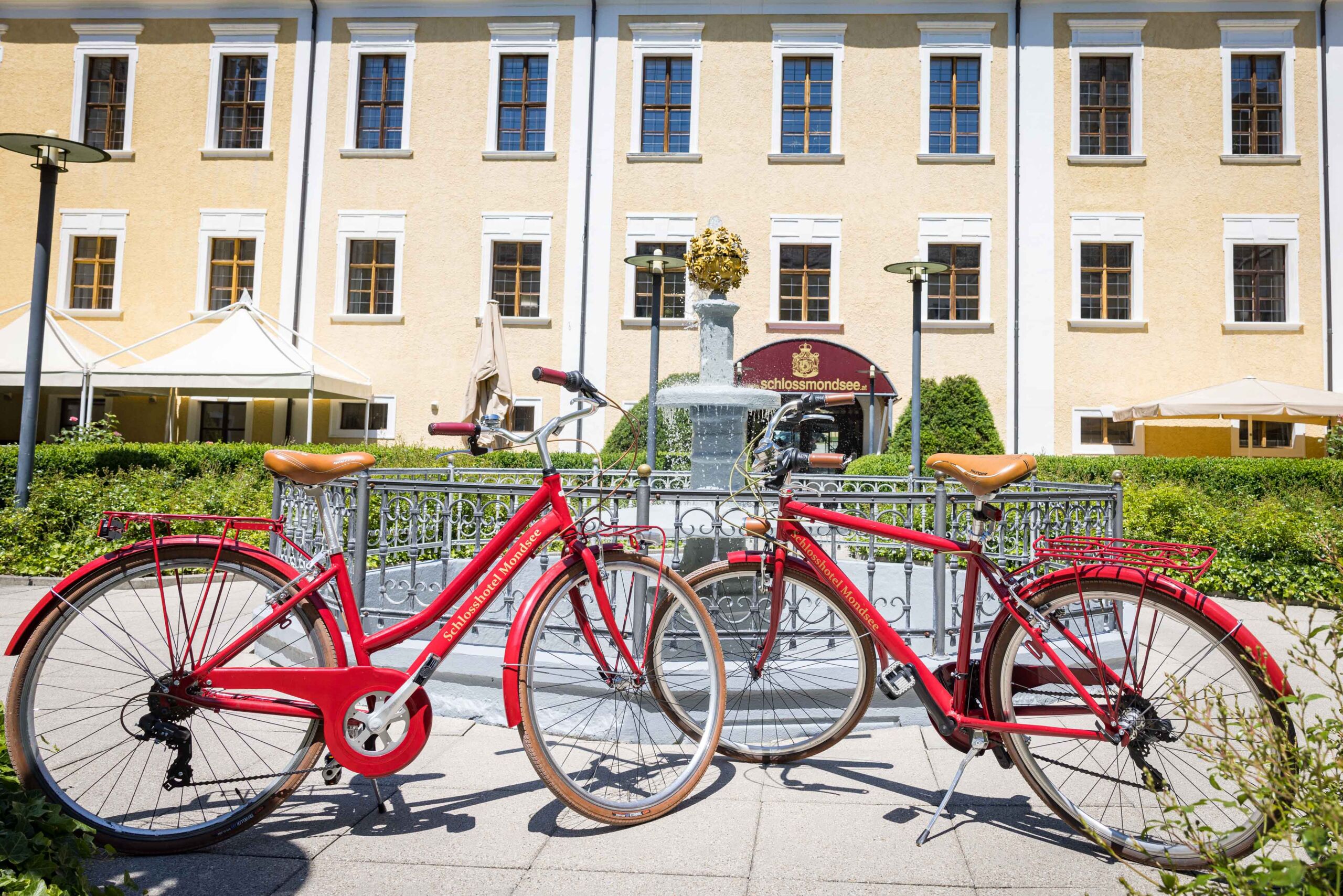 Mehrere Leihfahrräder stehen vor dem Schloss Mondsee und laden zu einer Radtour durch die Umgebung ein